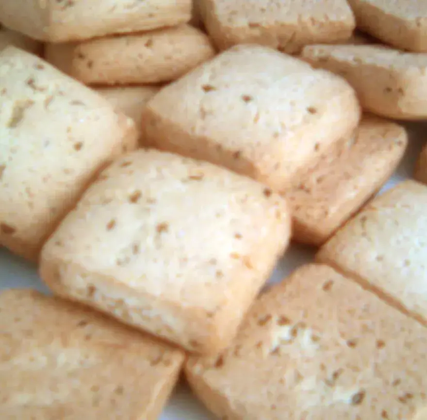 Assiette de canistrelli, biscuits corses carrés et dorés, parsemés de graines d’anis