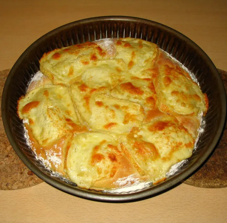 Flamiche au maroilles sortie du four dans un moule rond, fromage fondu et gratiné en surface
