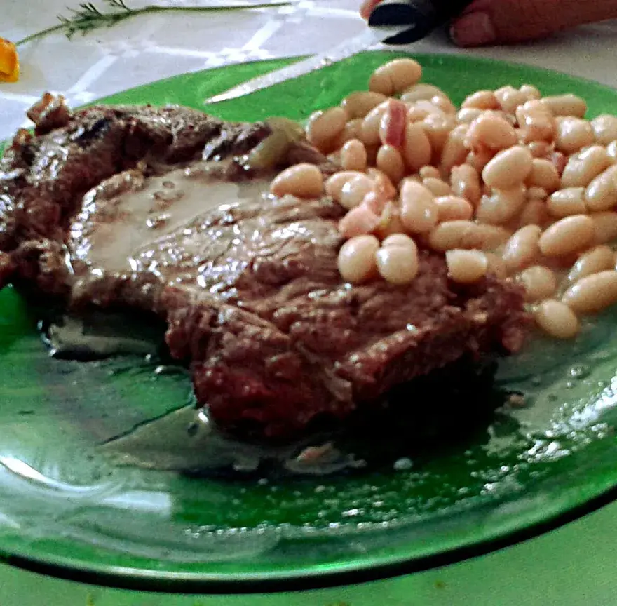 Assiette de mogettes, les haricots blancs de Vendée, servies avec une tranche de viande grillée et sa sauce